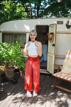 Happy hippie girl are having a good time in a camper trailer. Holiday, vacation, trip concept.High quality photo