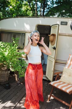 Happy hippie girl are having a good time in a camper trailer. Holiday, vacation, trip concept.High quality photo