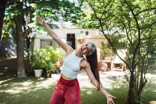 Happy hippie girl are having a good time in a camper trailer. Holiday, vacation, trip concept.High quality photo