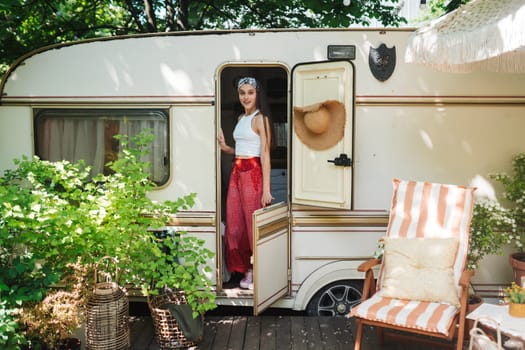 Happy hippie girl are having a good time in a camper trailer. Holiday, vacation, trip concept.High quality photo