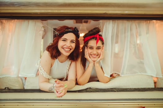 Happy hippie friends are having a good time together in a camper trailer. Holiday, vacation, trip concept. High quality photo