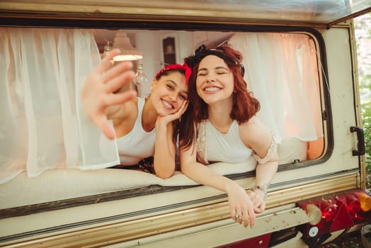 Happy hippie friends are having a good time together in a camper trailer. Holiday, vacation, trip concept. High quality photo