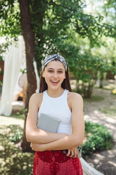 Happy hippie girl with book in her hands is having a good time with playing in camper trailer. Holiday, vacation, trip concept.High quality photo
