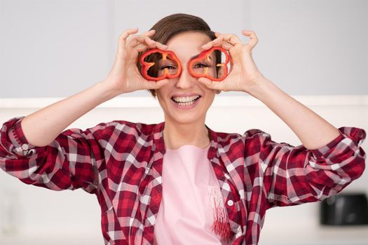 Short hair woman in red shirt playing with food, cut slices of sweet paper while cooking in the white kitchen. Healthy food at home. Healthy food leaving concept. 