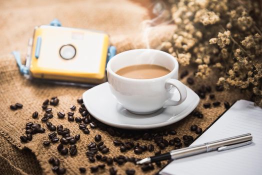 Coffee cup and coffee beans on wood table