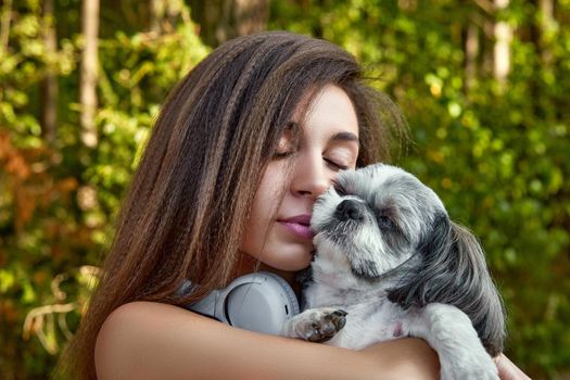 Oung woman with her cute Shih Tzu. Hugs a beautiful pet