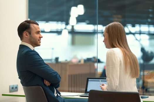 Interviewing employee beautiful girl. Close-up of two business people sitting in the workplace with documents on the table. Successful interview with a supervisor and employee.