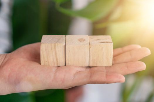 Blank wooden cube that you can put text or icon on in hand hold background