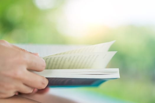 Woman is reading book in beautiful park and pond relax and peaceful environment background.