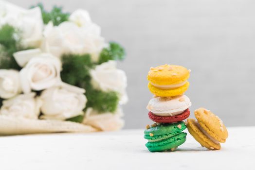 colourful french macaroons with white rose on white background