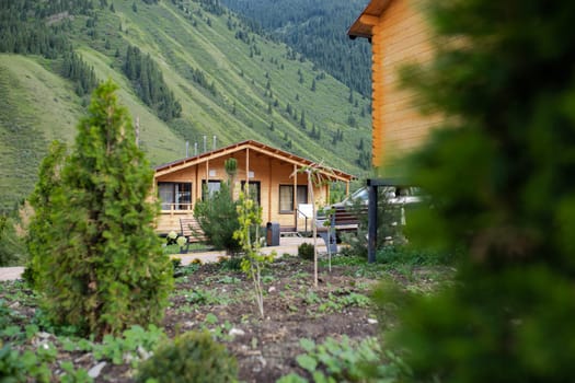 a wooden house outside the city in a mountainous area among trees.