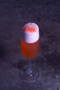 top view of an orange summer cold cocktail on a gray background.