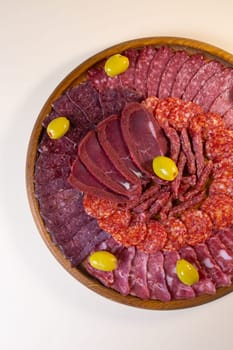 meat sliced from delicacies on a wooden stand top view.