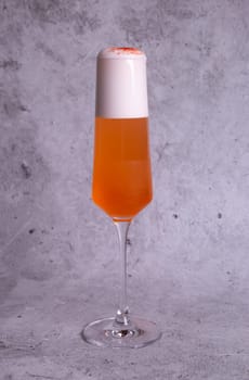 Orange summer cold cocktail on a gray background.