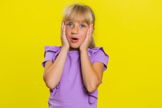 Oh my God, Wow. Young preteen child girl kid looking surprised at camera with big eyes, shocked by sudden victory game winning lottery goal achievemen good news. Children isolated on yellow background