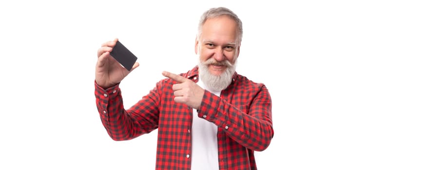 handsome 60s retired man with white beard and mustache showing bank card.