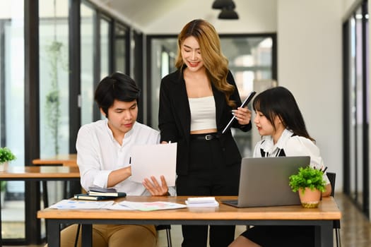 Millennial woman business team leader explaining project information to colleague.