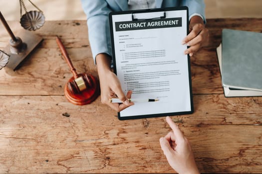 Young African American lawyer studying a case for a client and signing a legal contract to fight her opponent in court. Legal and lawyer concepts