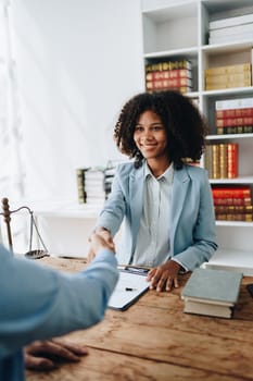 Law, consultation, agreement, contract, lawyer or attorney shakes hands to agree on the client's offer to be hired to fight the parties in court