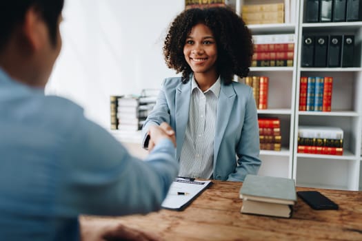 Law, consultation, agreement, contract, lawyer or attorney shakes hands to agree on the client's offer to be hired to fight the parties in court