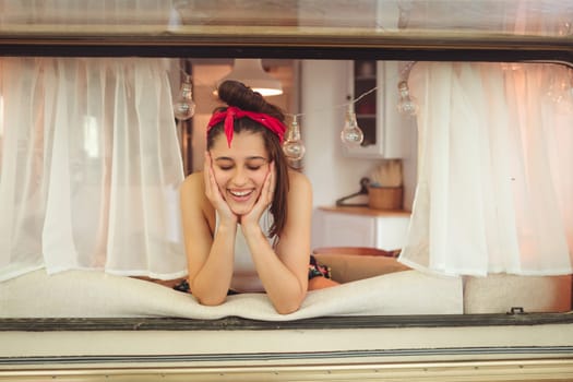 Happy hippie girl are having a good time in a camper trailer. Holiday, vacation, trip concept.High quality photo