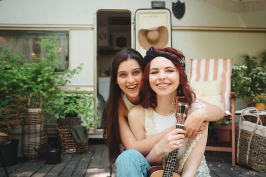 Happy hippie friends are having a good time together in camper trailer. Holiday, vacation, trip concept. High quality photo