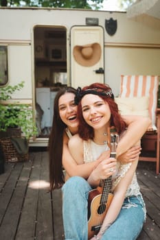 Happy hippie friends are having a good time together in camper trailer. Holiday, vacation, trip concept. High quality photo