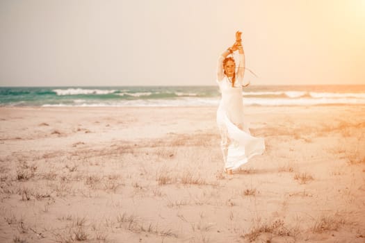 woman sea white dress. Model in boho style in a white long dress and silver jewelry on the beach. Her hair is braided, and there are many bracelets on her arms