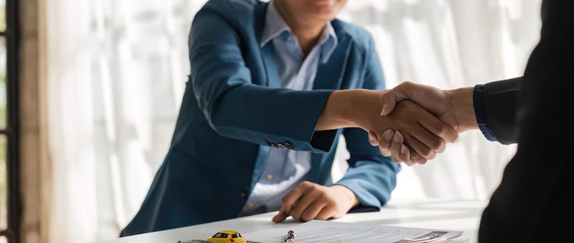 Handshake of cooperation customer and salesman after agreement, successful car loan contract buying or selling new vehicle.