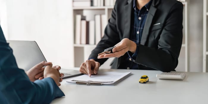 Transportation sell automotive business concept. Close up hands of sell auto agent giving car remote key to client to travel sightseeing.