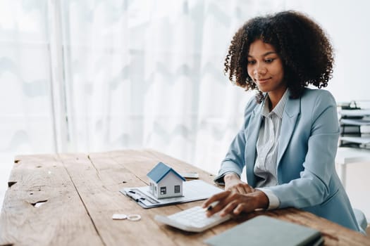 Real estate agent, African American businesswoman Africans use smartphone and calculators to offer mortgages to their clients. Home mortgage and insurance finance concepts