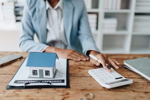 Real estate agent, African American businesswoman Africans use smartphone and calculators to offer mortgages to their clients. Home mortgage and insurance finance concepts