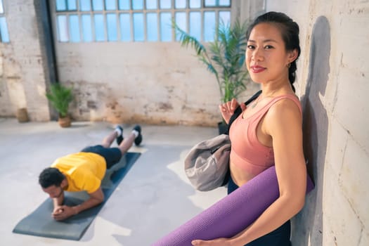 Fitness Harmony: Chinese Woman Smiling as Black Athlete Exercises. High quality photo