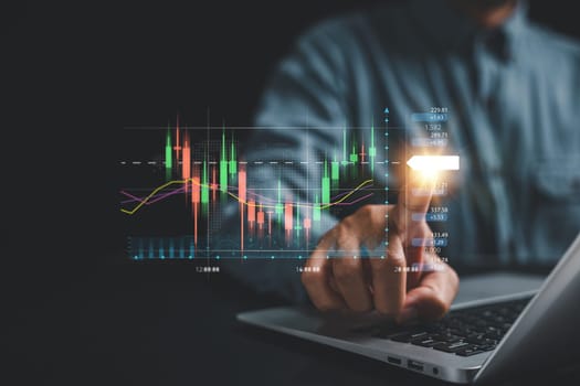 Investment strategy and progress concept. Trader's hand points at a virtual hologram stock on a screen, showcasing the path to business growth and success through strategic investment planning.