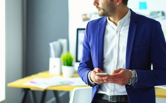 Portrait of young designer in front of laptop and computer while working