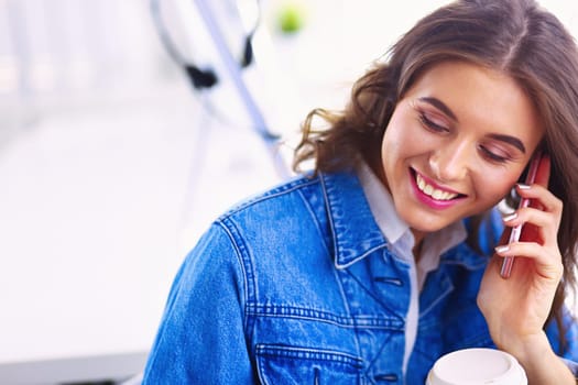 Young businesswoman talking on the phone in coffee shop.