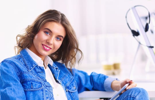 Portrait of beautiful business woman working at her desk with headset and laptop.