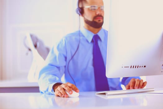 Businessman in the office on the phone with headset, Skype, FaceTime.