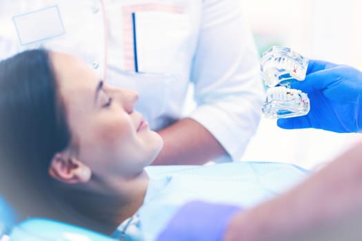 Portrait of a dentist who treats teeth of young woman patient.