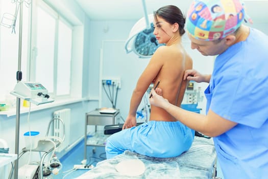 Doctor showing young patient her chest in his office at the hospital.