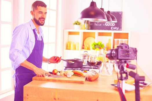 Man holding paper bag full of groceries on the kitchen background. Shopping and healthy food concept.