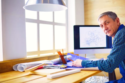 Architect working on drawing table in office.