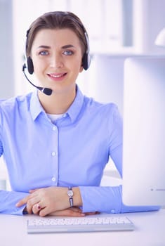 Serious pretty young woman working as support phone operator with headset in office.