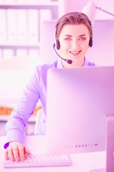 Serious pretty young woman working as support phone operator with headset in office.