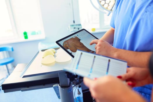 Doctor showing young patient her chest in his office at the hospital.