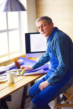 Architect working on drawing table in office.