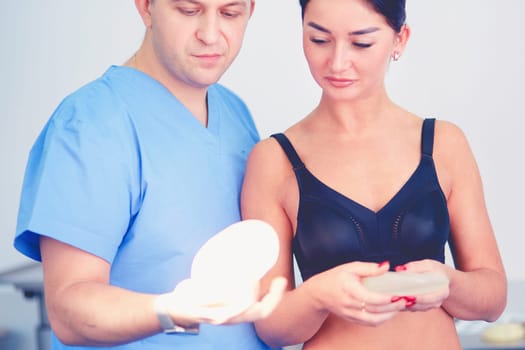 Doctor showing young patient her chest in his office at the hospital.