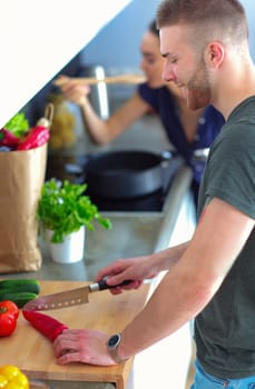 Couple cooking together in their kitchen at home.