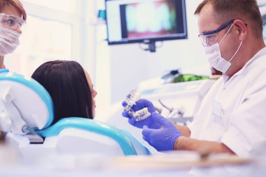 Beautiful senior woman at dentist having dental treatment at dentist's office.