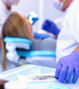 Detail of hand holding dental tools in dental clinic. Dentist Concept.